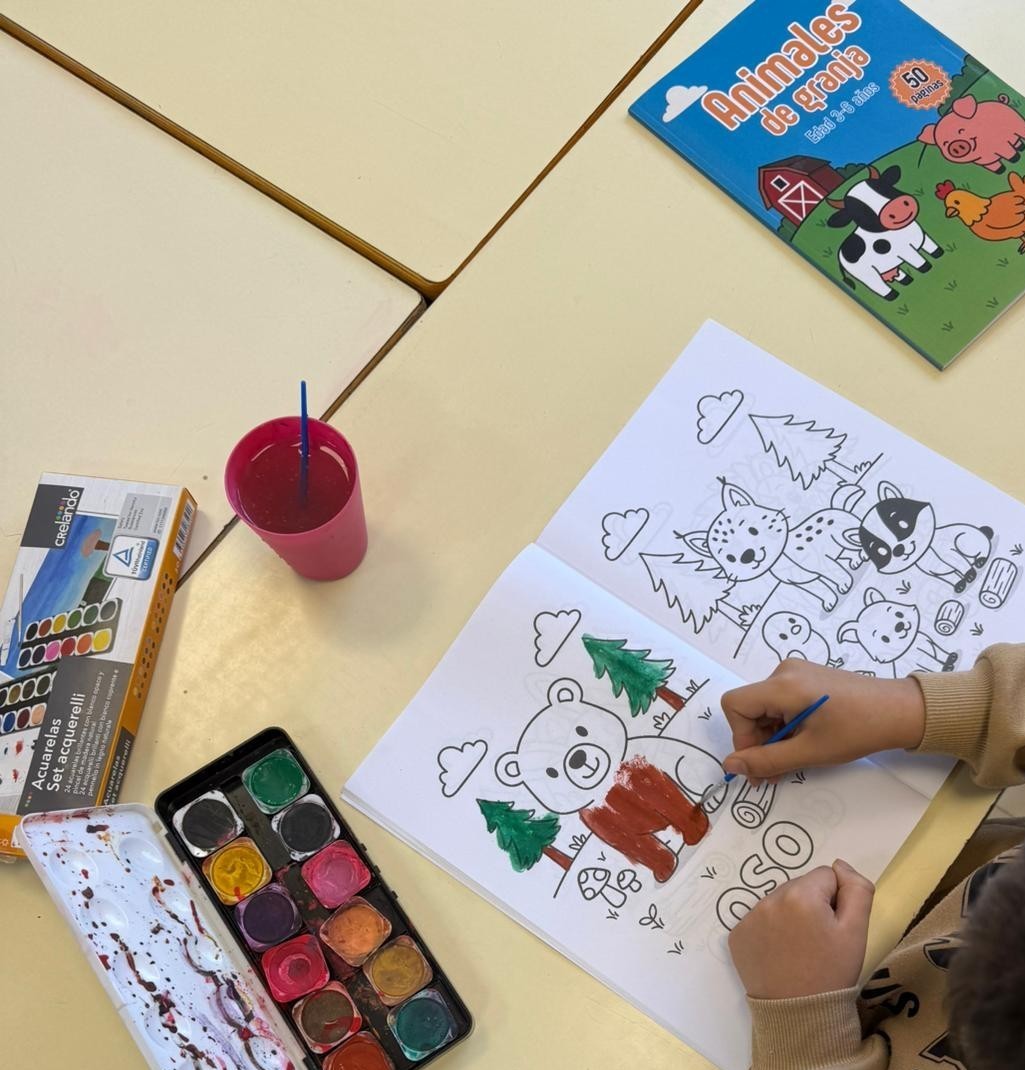 Niños coloreando nuestros libros en clase
